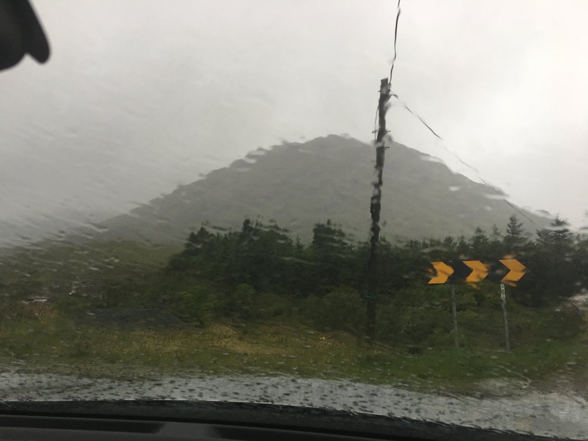 View of mountains through rain covered windshield.