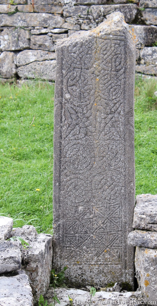 Broken, ancient tombstone with Celtic designs carved on it. 