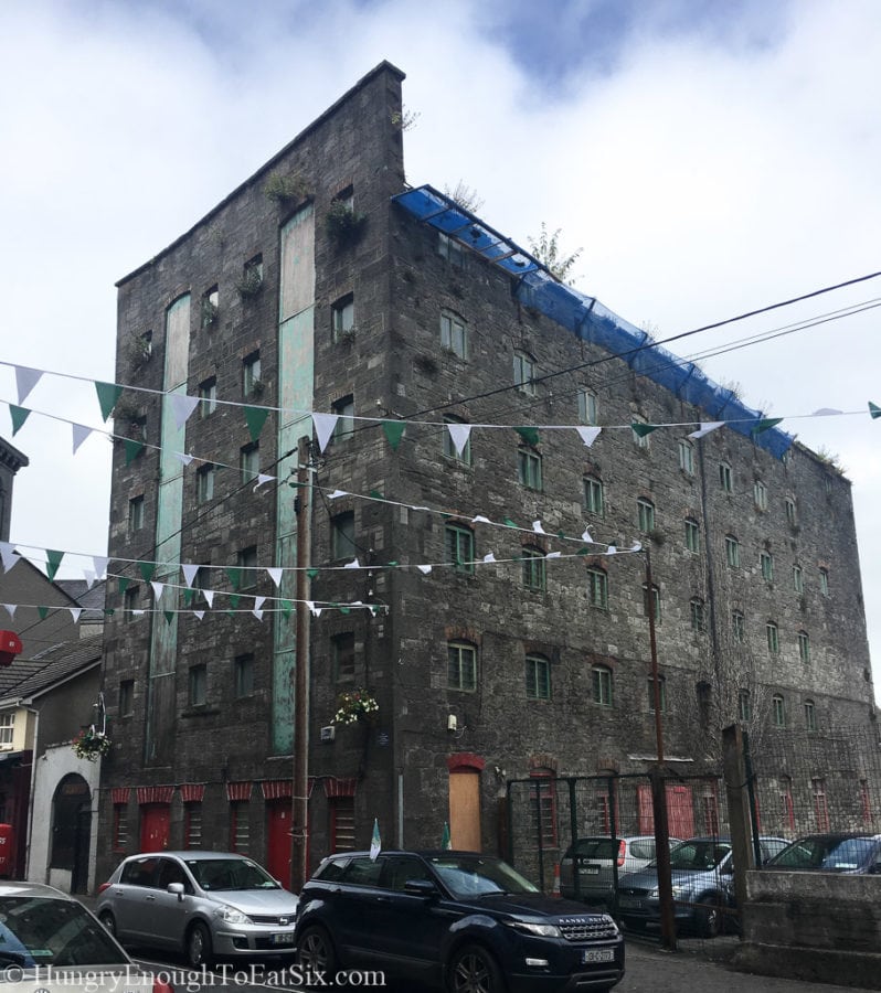 Building in Limerick, Ireland with green and white banners strung across the street. 