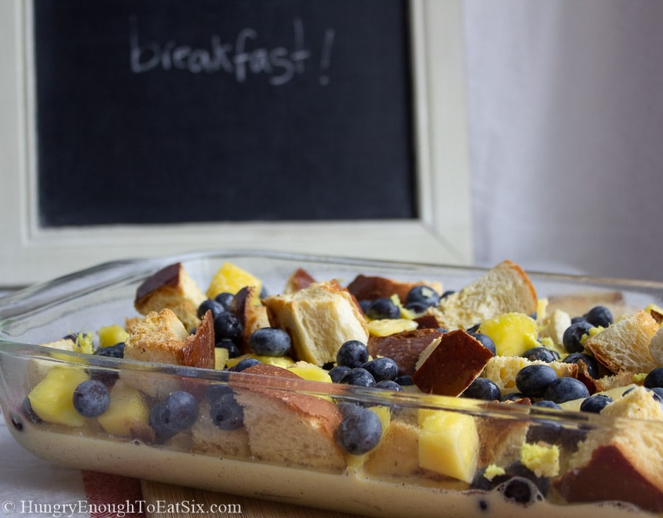 Image of a pan of unbaked bread pudding with a sign that says "breakfast"