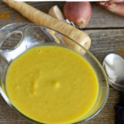 Yellow curried parsnip soup in a glass bowl.
