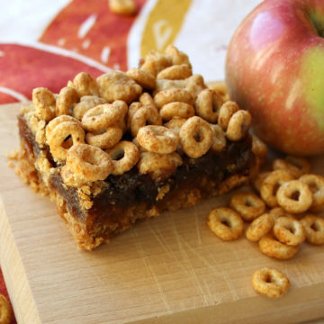 Cheerios and an apple on a board next to apple bars