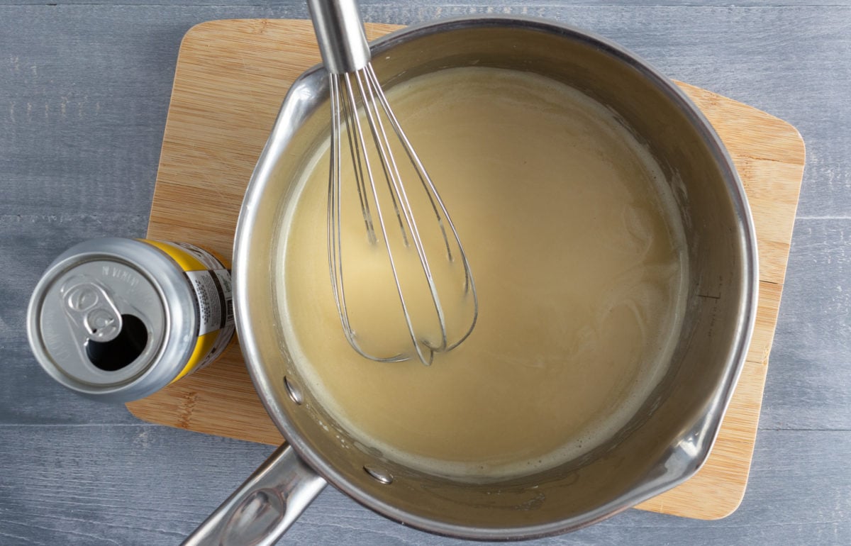 White sauce in saucepan with whisk