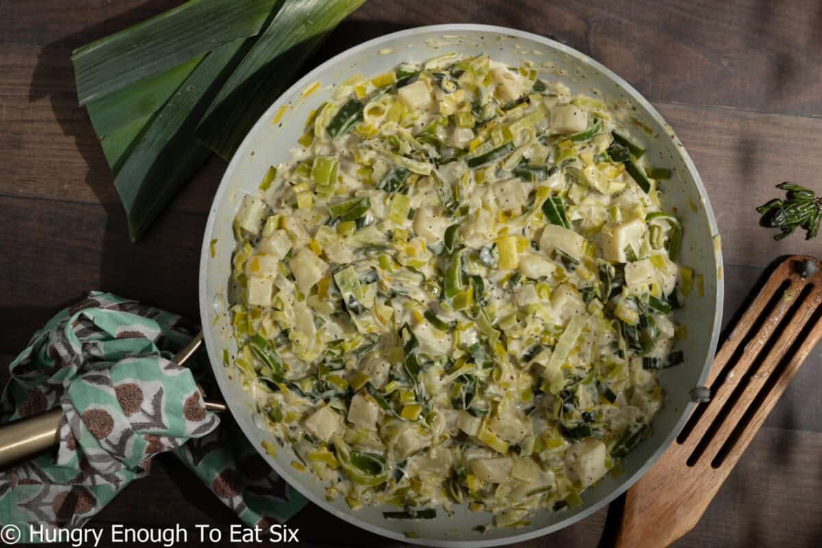 Cooked filling of leeks, potatoes, and cream in a skillet.
