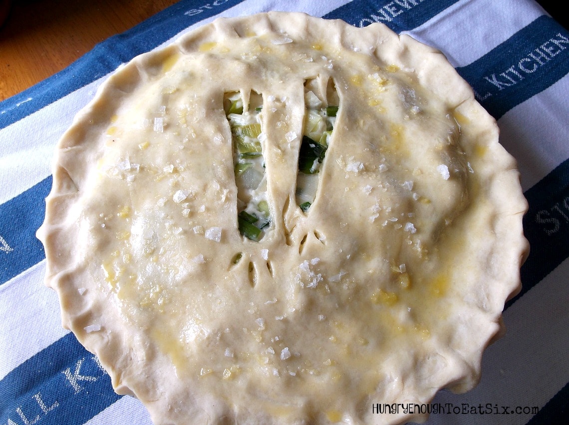 Unbaked pie with top crust brushed with egg wash and with cutouts