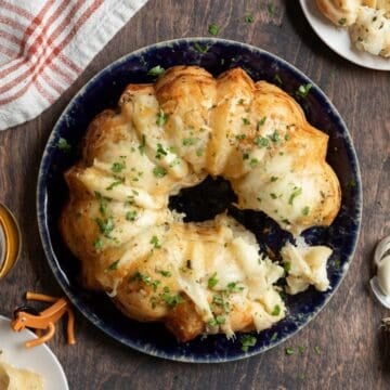 Top of a cheesy garlic pull-apart bread with a bit taken out.