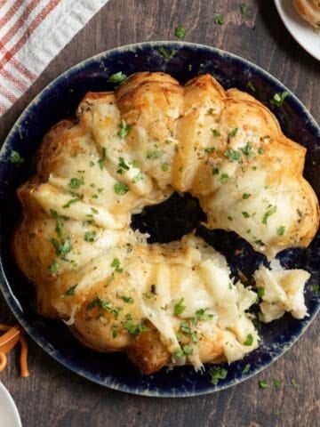 Top of a cheesy garlic pull-apart bread with a bit taken out.