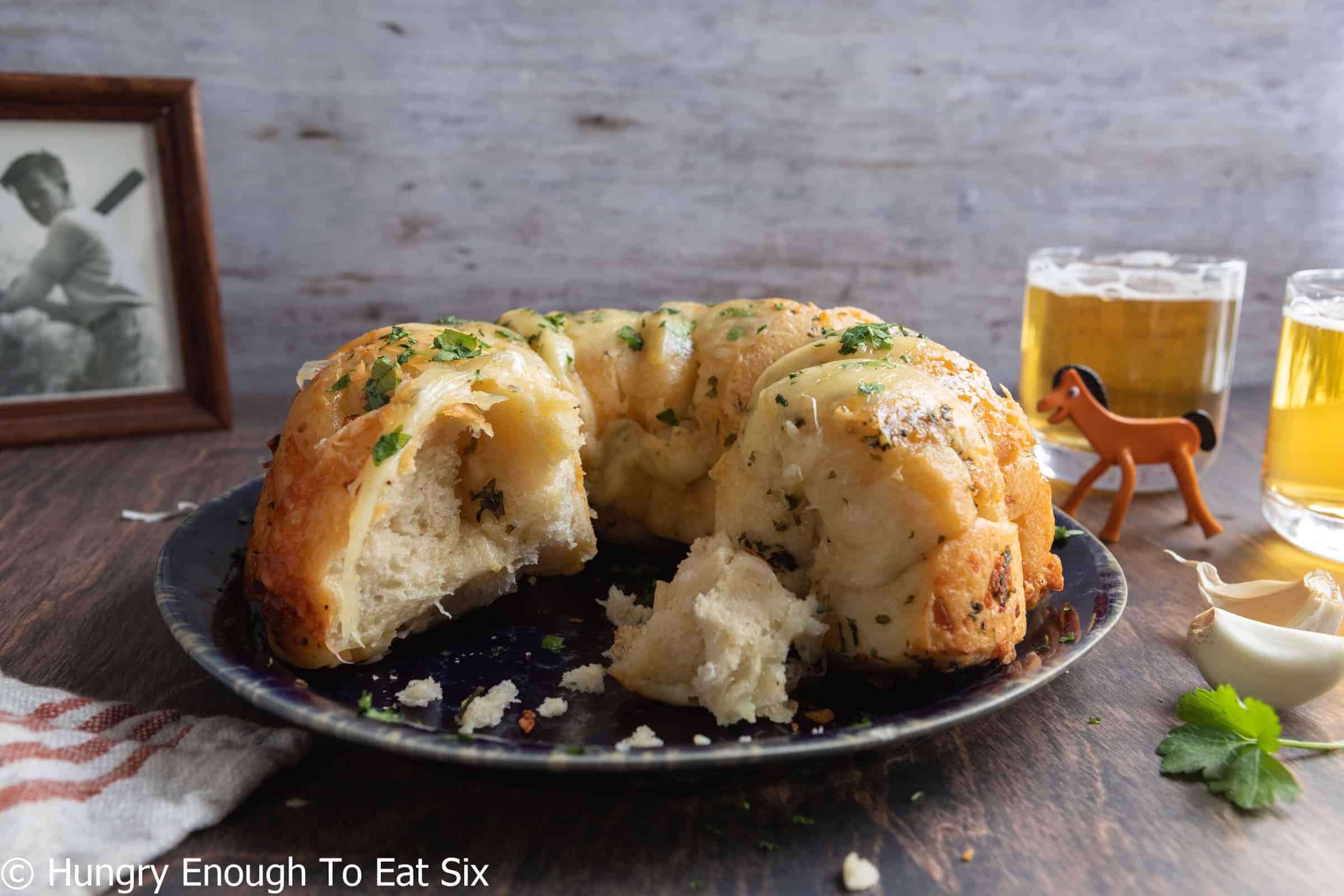 Interior of a baked cheesy garlic tear-and-share bread, served on a blue plate.