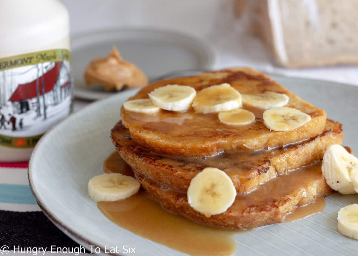Slices of French toast with syrup and banana slices.