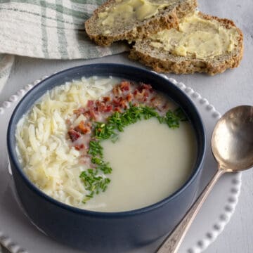 Creamy soup in a bowl with cheese and toppings.