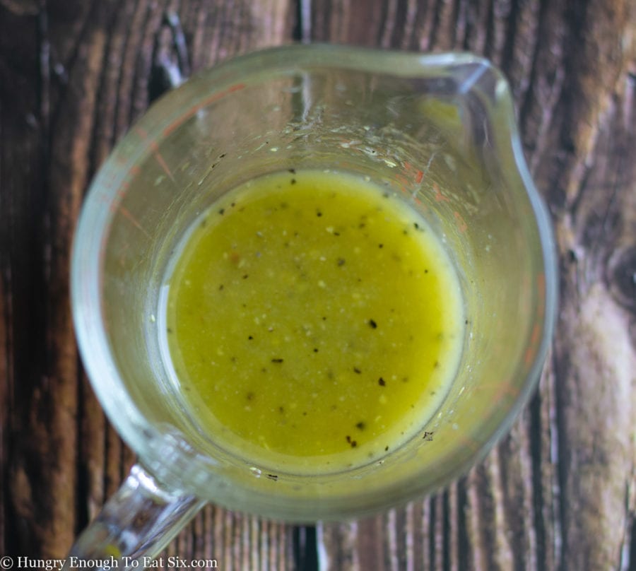 Mustard vinaigrette dressing in a measuring cup.