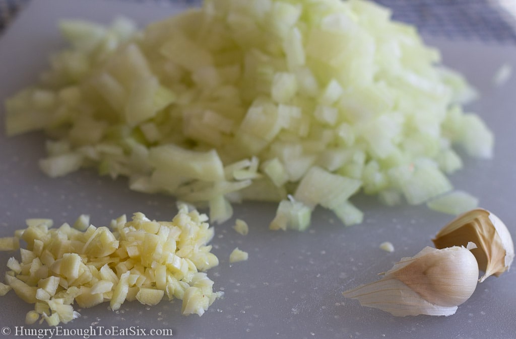 Diced onion and diced garlic on a board