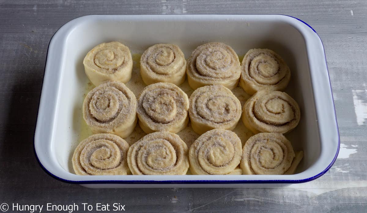 Unbaked swirled bun slices in a baking dish.