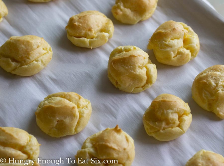 Baked choux pastry puffs on a baking sheet