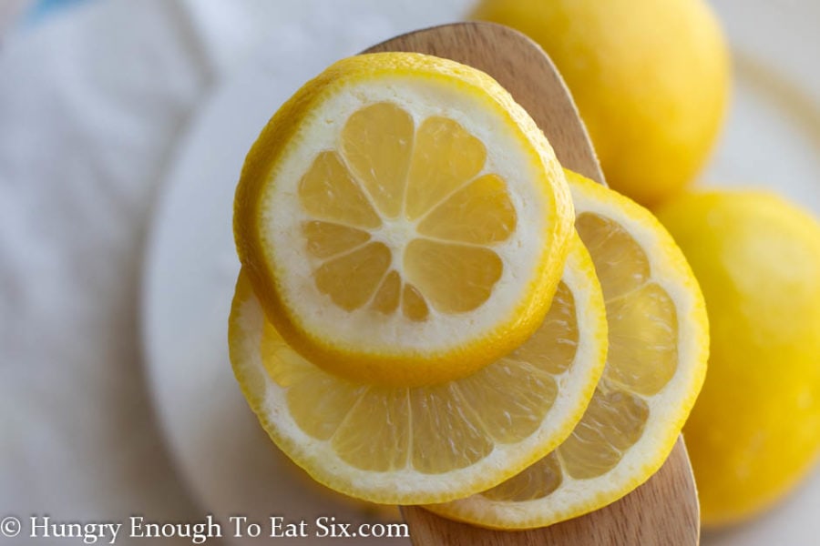 Slices of lemon resting o a wood spatula