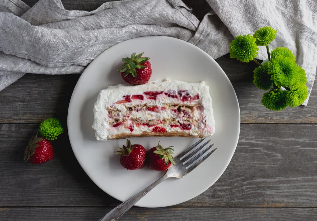 White plate with icebox cake slice and berries
