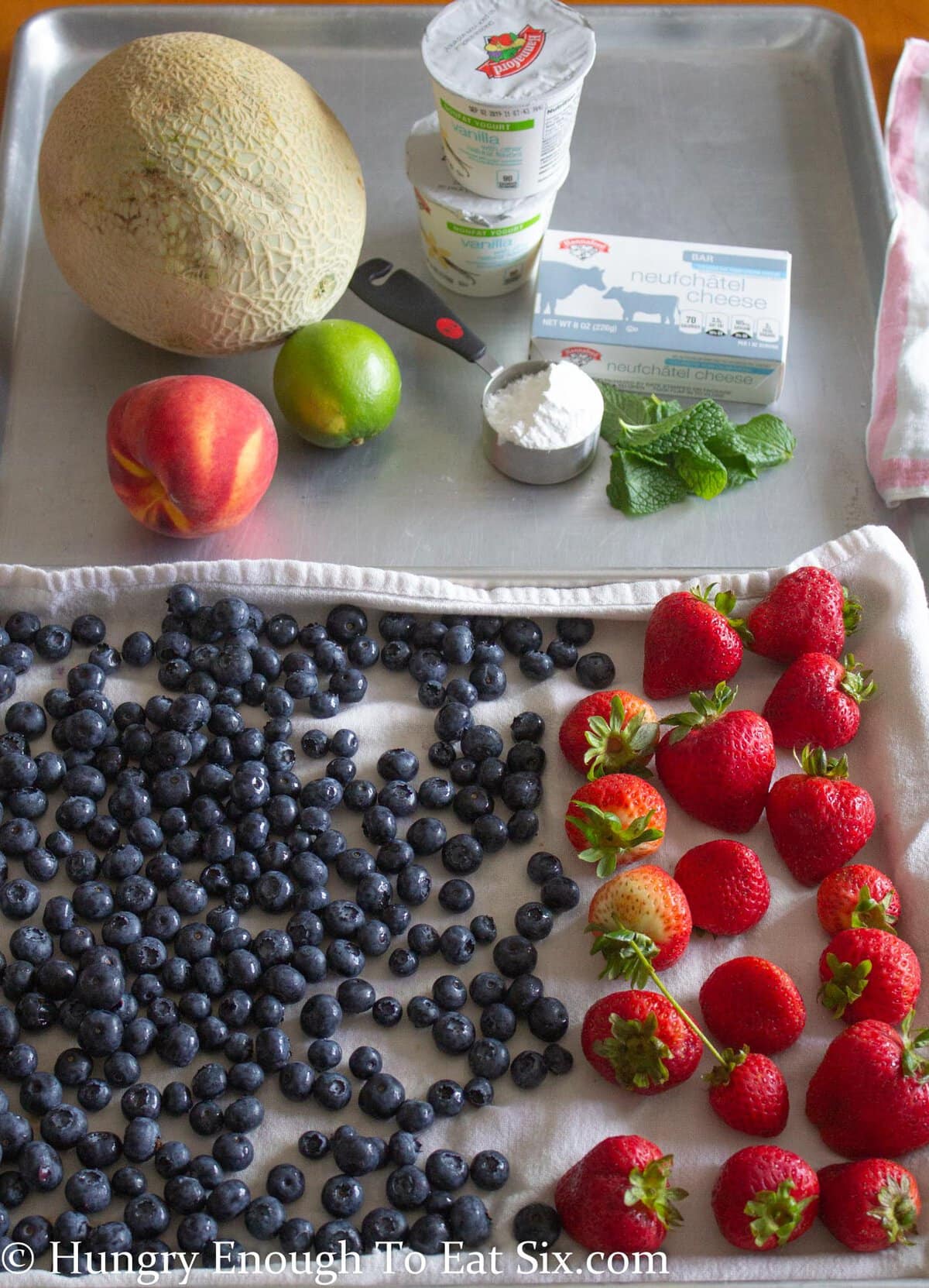 Blueberries and strawberries spread on a kitchen towel.
