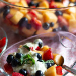 Glass bowl with fruit salad and cream.