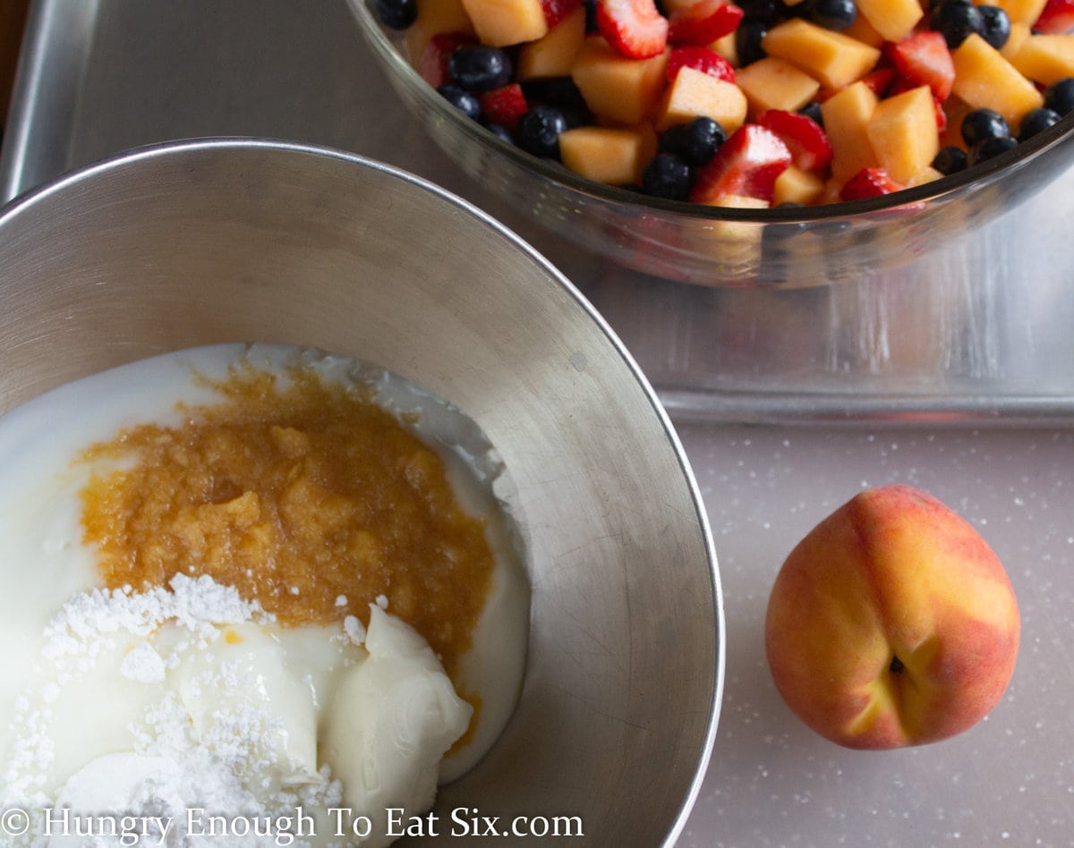 peach puree and cream cheese in a metal mixing bowl.