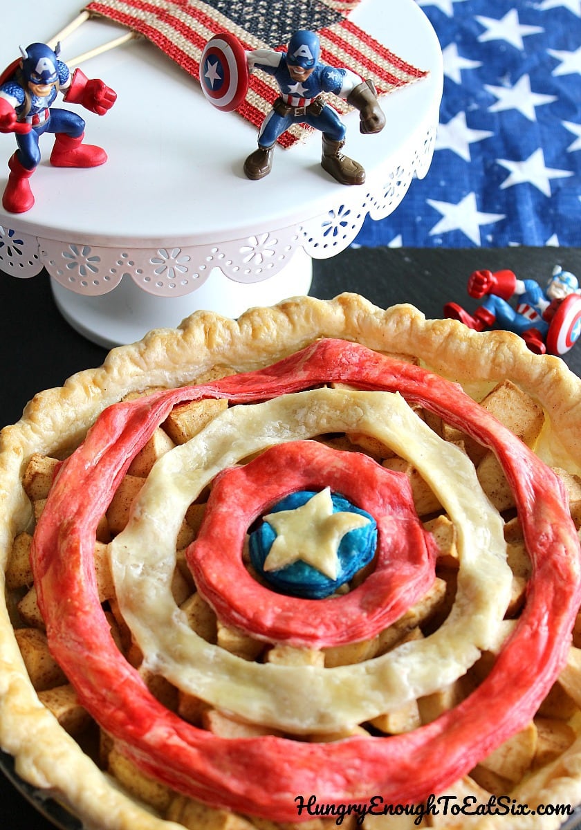 Action figure toys near an apple pie with colorful rings