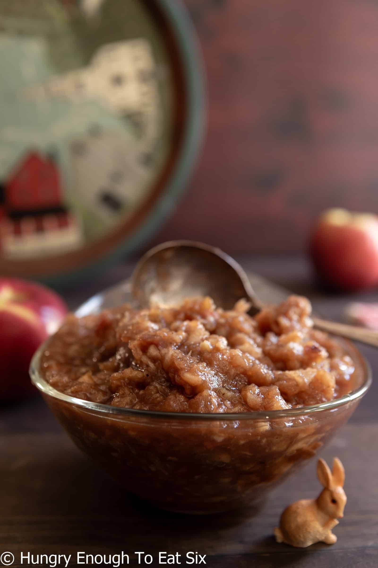 Rustic brown homemade applesauce in a dish with a spoon.