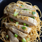 Sliced chicken and scallions with sesame noodles, text overlay.