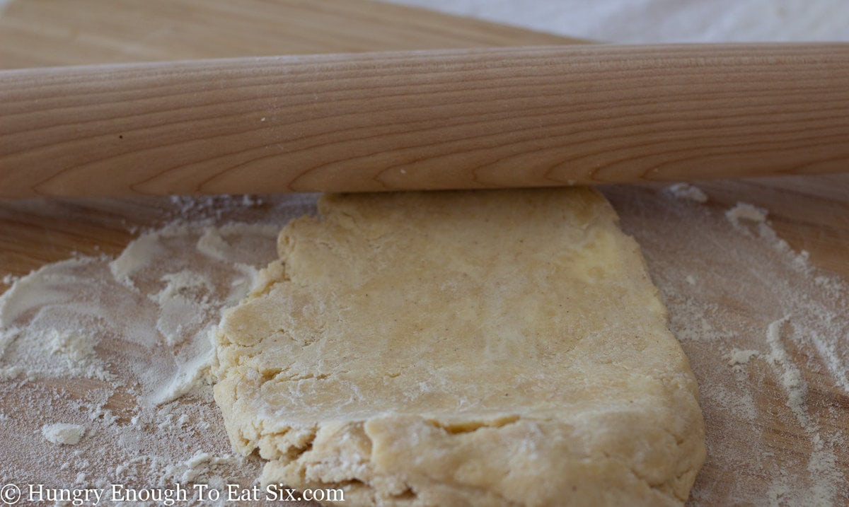 Mound of pie crust down pressed flat under rolling pin