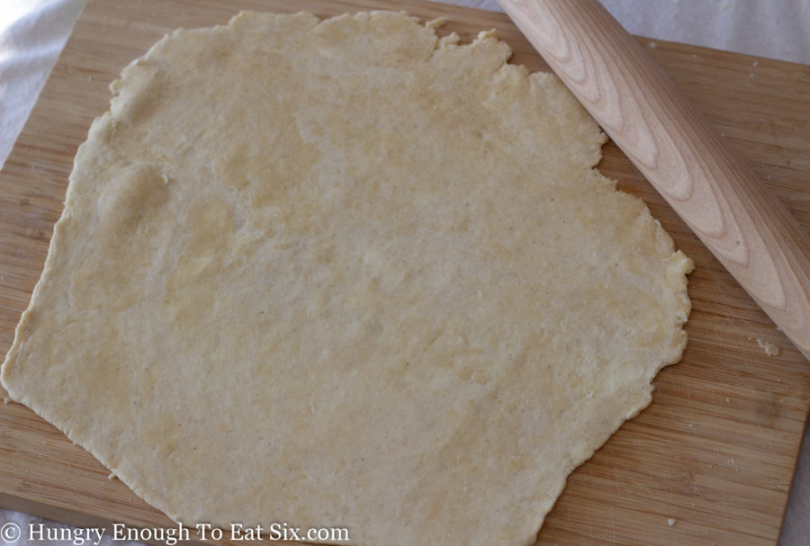 Rolled out pie crust dough next to rolling pin