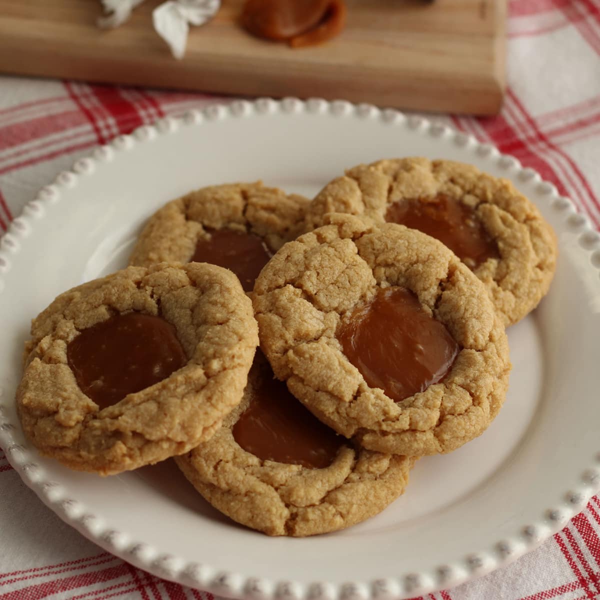 White plate with five peanut butter cookies