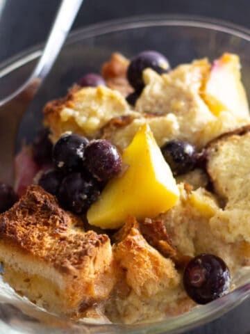 Blueberry and fruit bread pudding in glass dish.