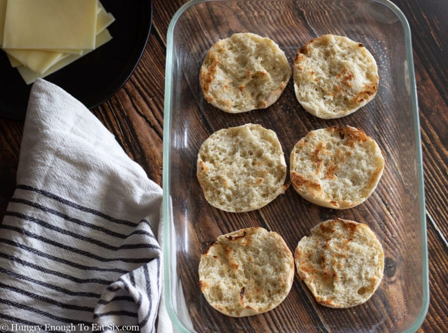 English muffin bottoms in a glass pan.