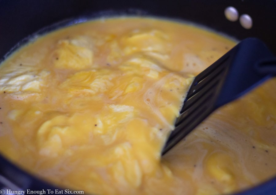Scrambled eggs cooking in a pan.