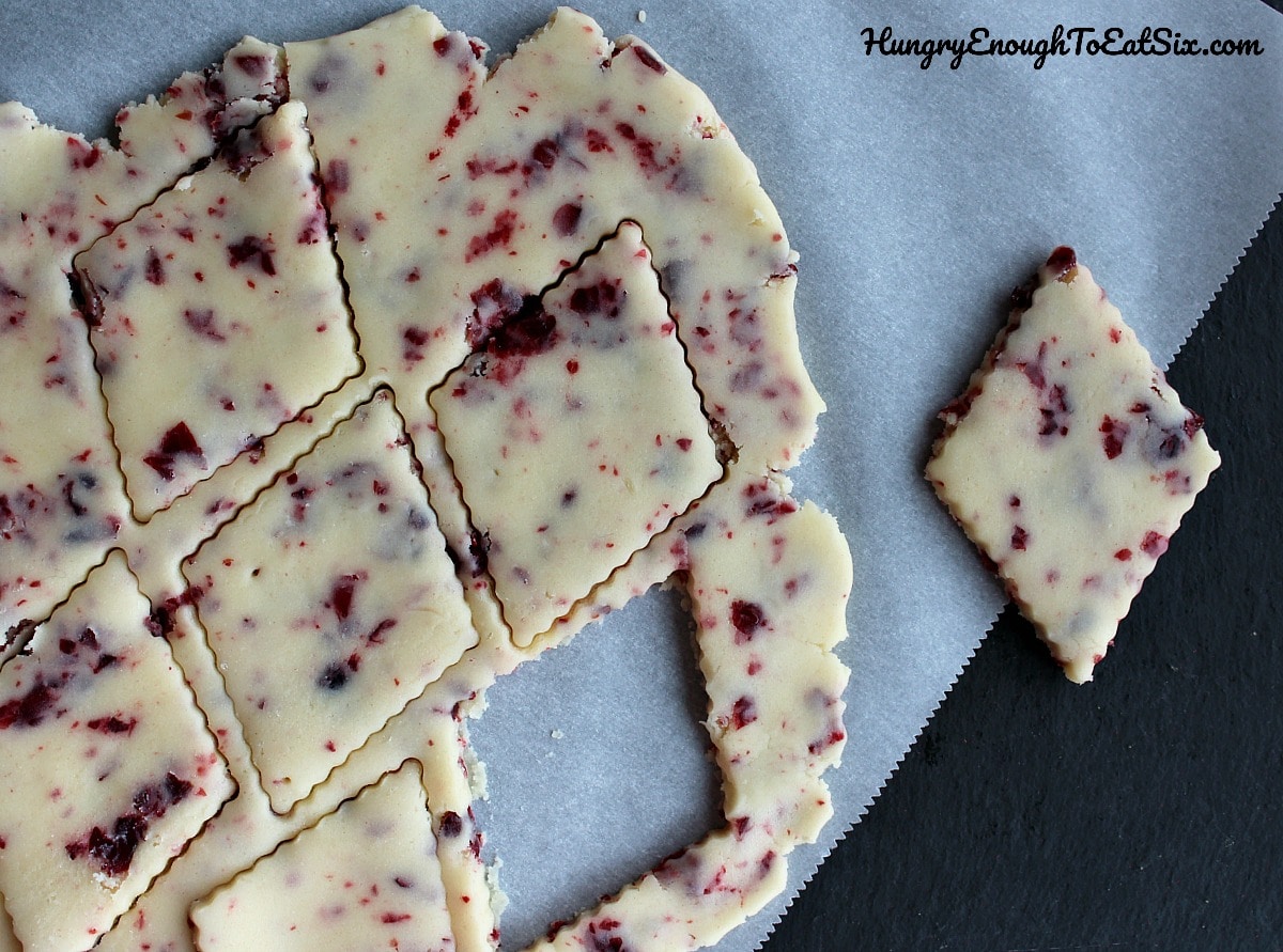 Shapes cut from cranberry butter cookie dough