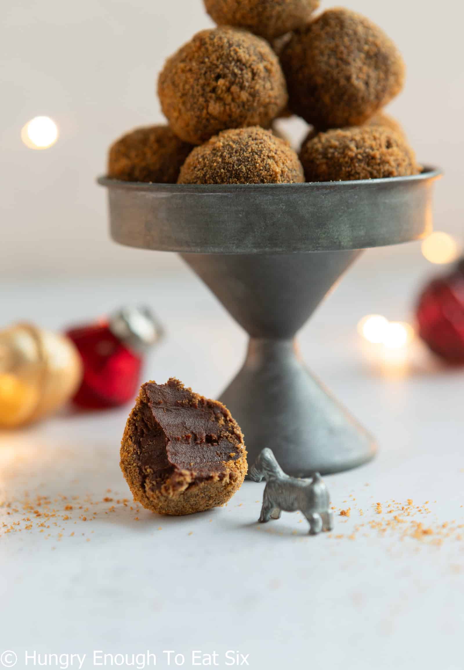 Ginger cookie chocolate truffle with a bite taken out and a small metal dog nearby.