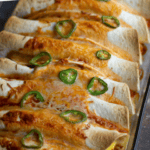 Burritos with cheese in a pan.