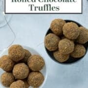 Two small dishes holding ginger cookie chocolate truffles on a white table.