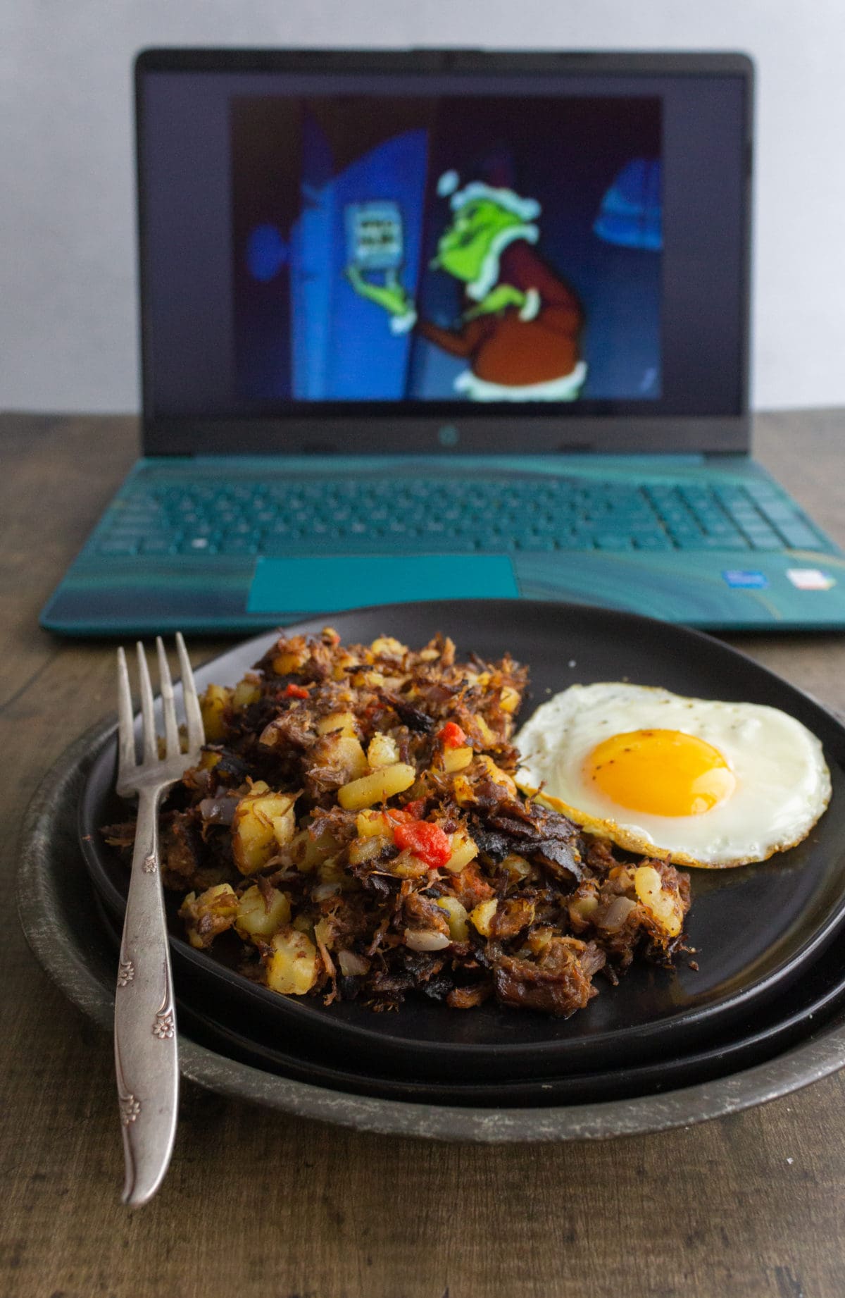 Laptop with plate of hash and egg
