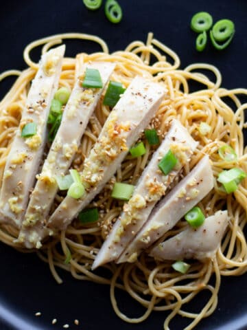 Sliced chicken with noodles and scallions.