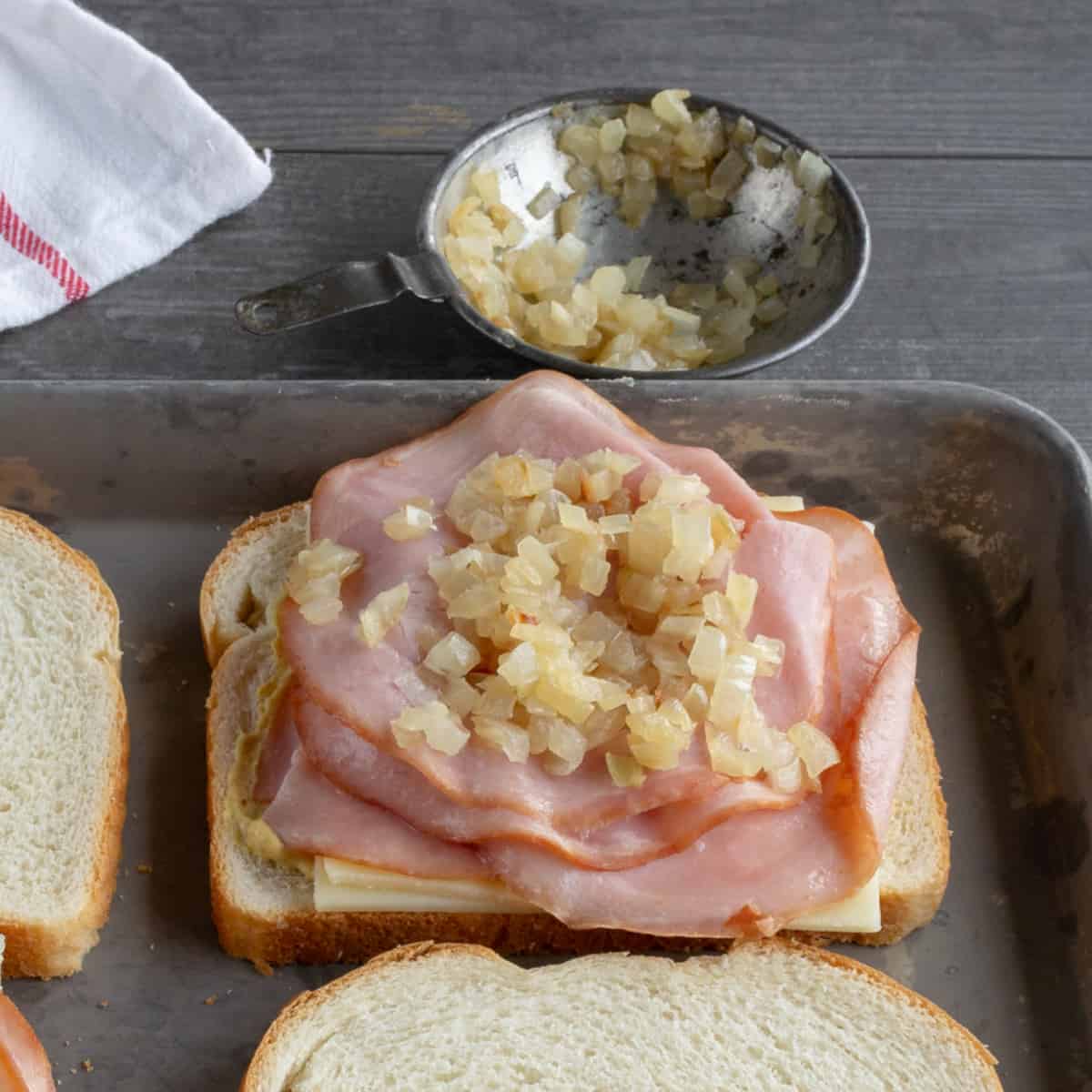 Diced, cooked onion on sandwich and in dish.