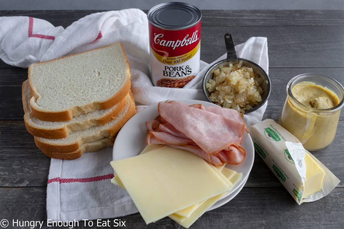Ingredients: white bread, canned beans, butter, sliced cheese, sliced ham, and diced onions.