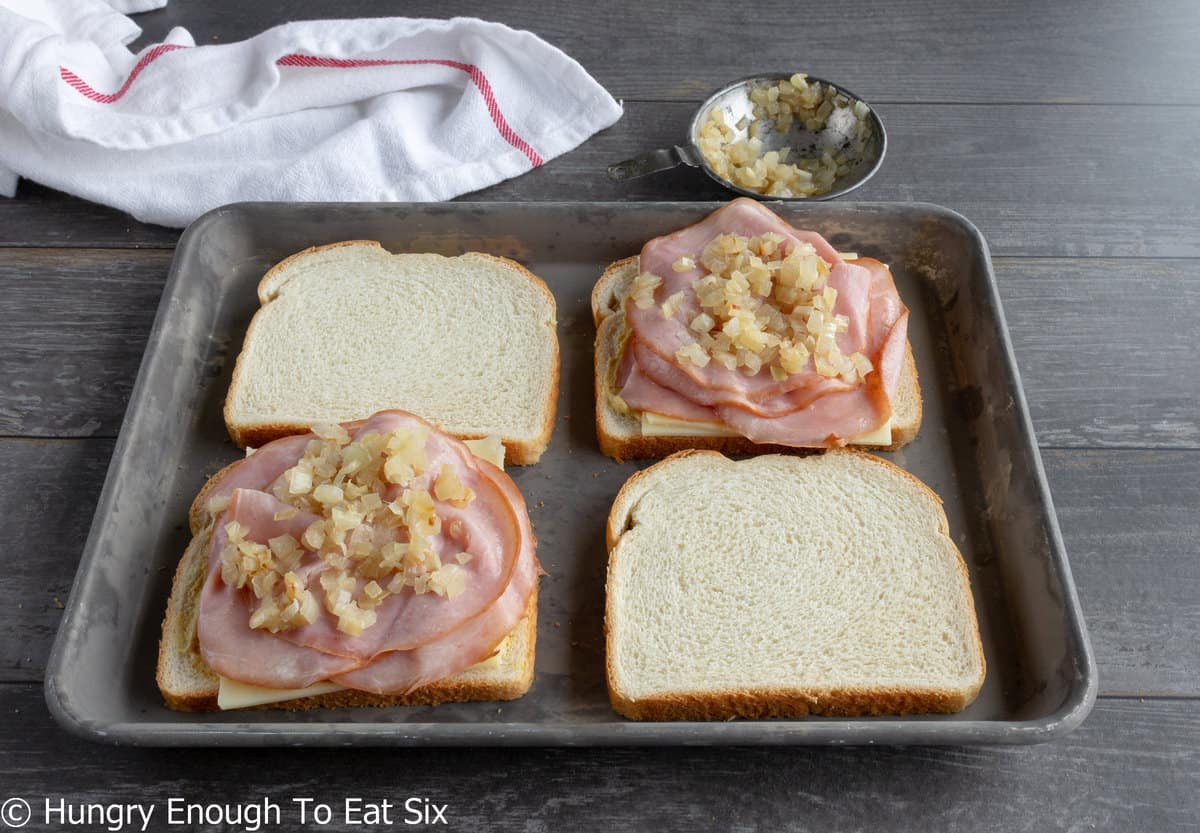 Bread slices with sliced ham and diced onion on top.