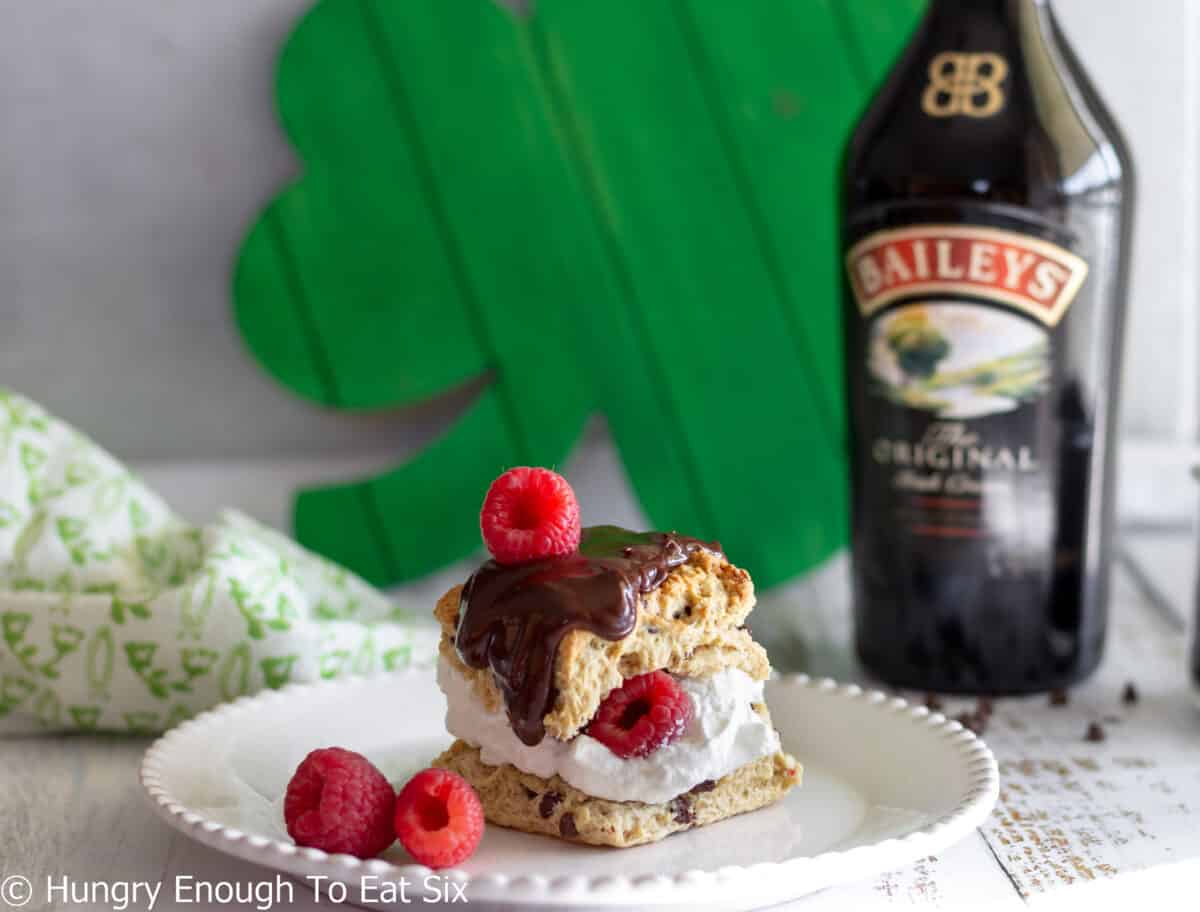 Scone with whipped cream, chocolate, and berries.