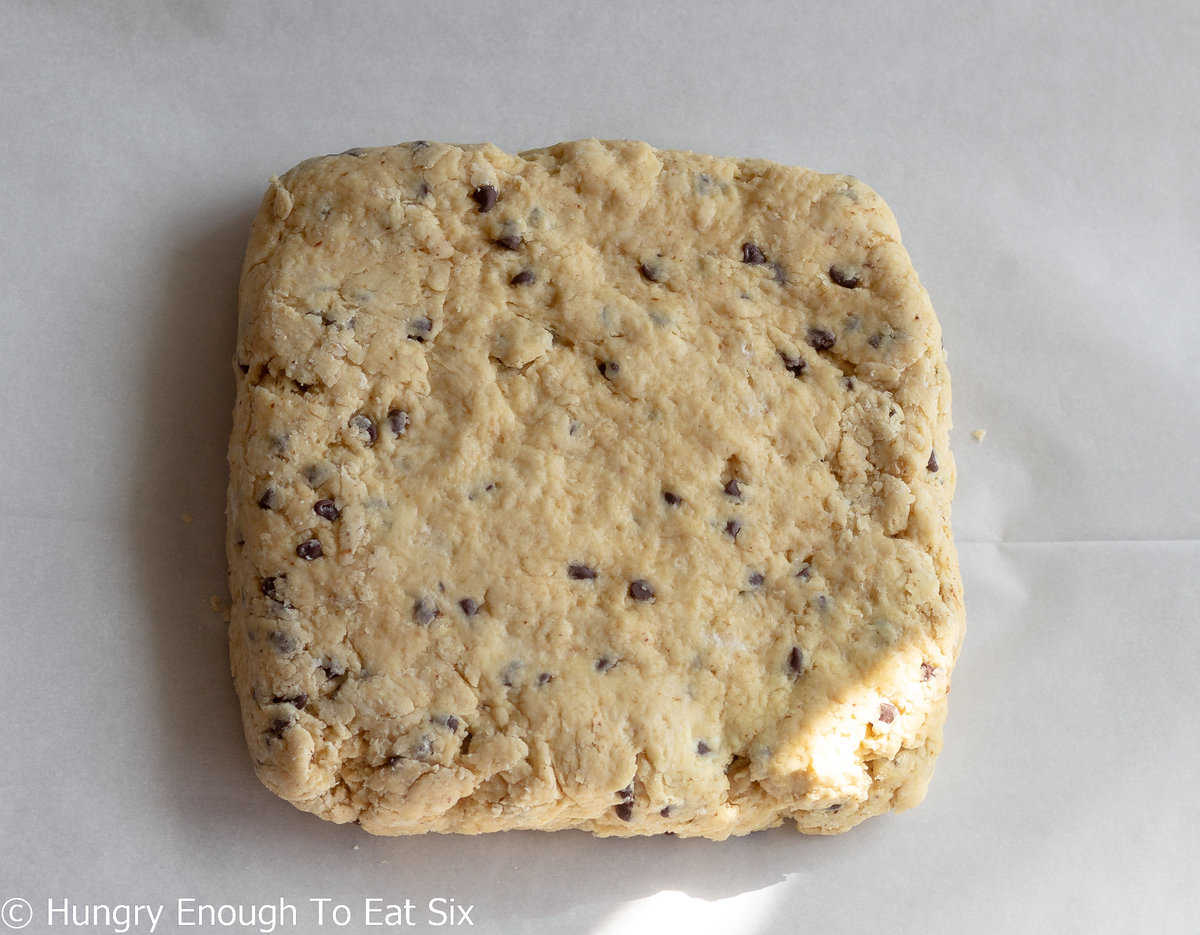 Scone dough with chocolate chips in a square shape.