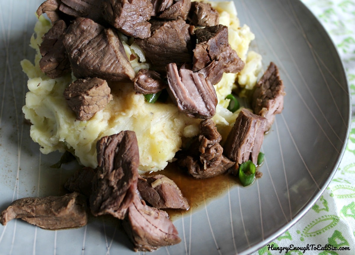 Gravy and meat on a plate with mashed potatoes