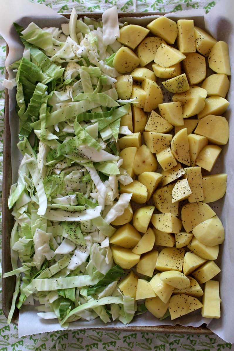 Raw cabbage and potatoes on a baking sheet