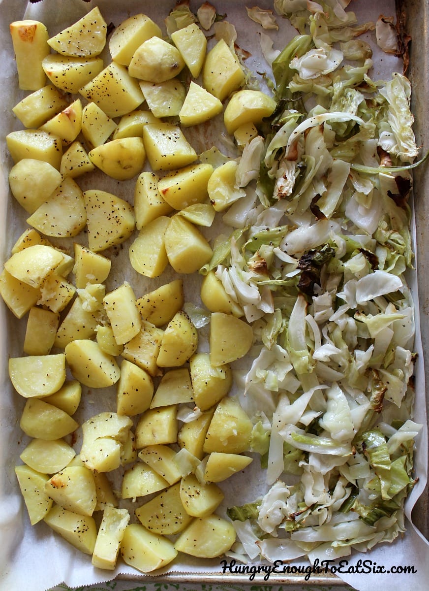 Roasted diced potatoes and chredded cabbage on a baking sheet