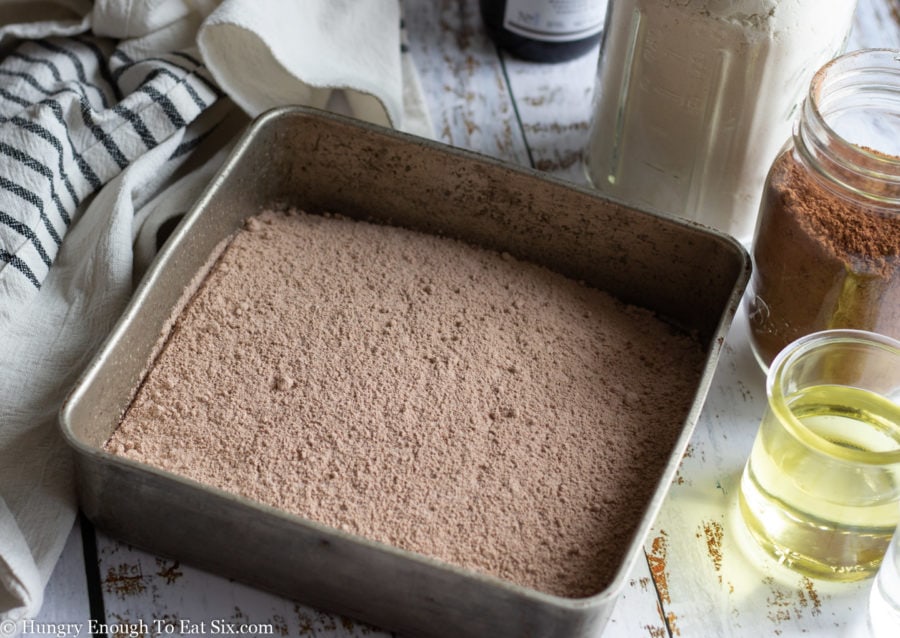 Dry ingredients for a chocolate cake in a square pan.