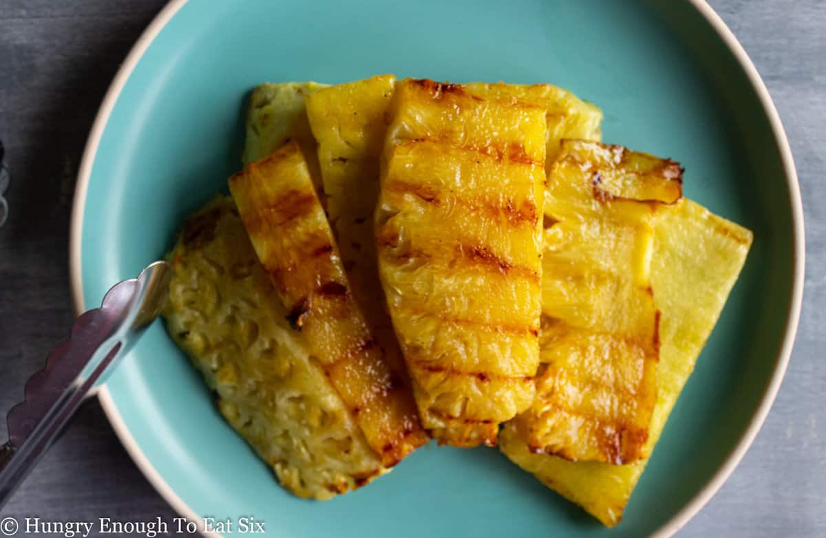 Grilled pineapple pieces on a blue plate