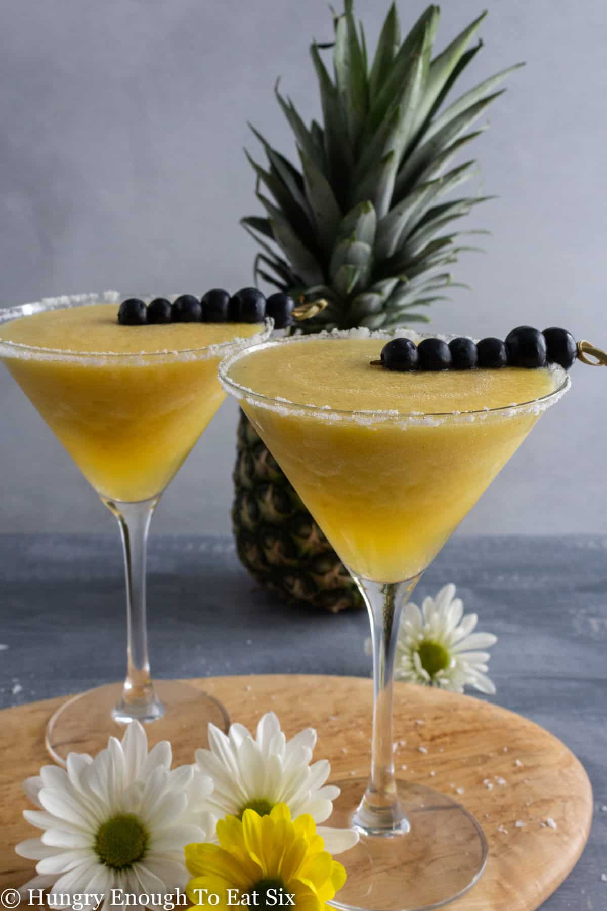 Two cocktails with blended pineapple drink