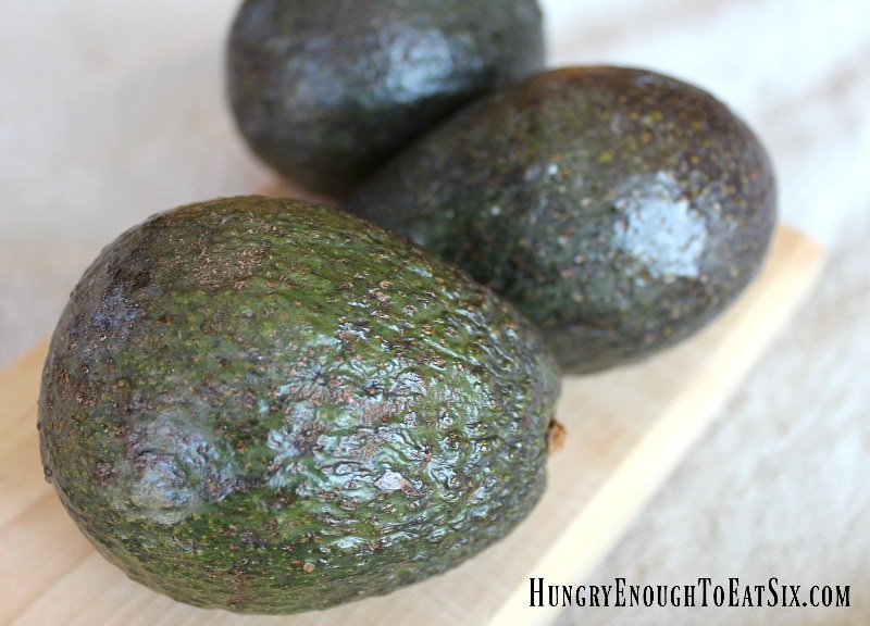 Three green avocados